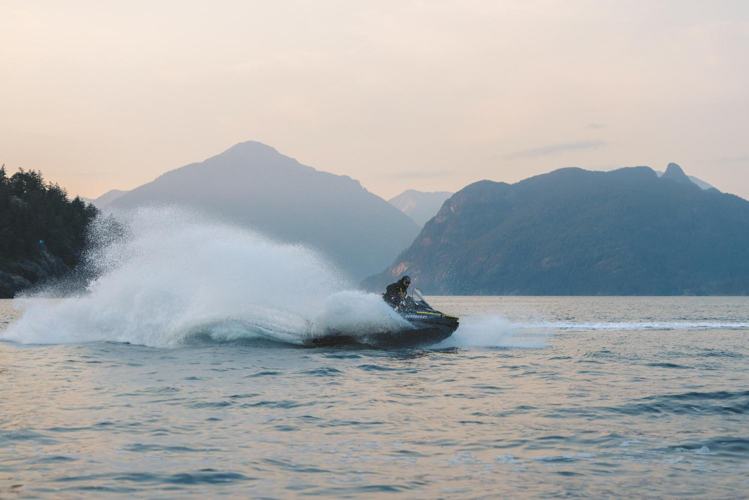 A rider navigates a jet ski through the vibrant ocean, creating splashes against the serene water backdrop. A rider navigates a jet ski through the vibrant ocean, creating splashes against the serene water backdrop.